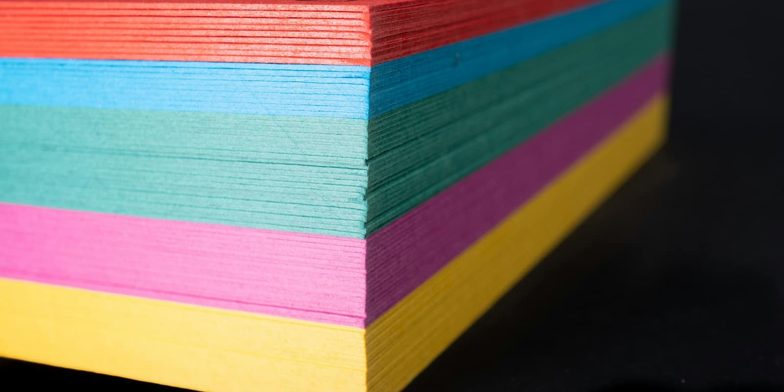 A stack of brightly colored card stock, edges fanned out.